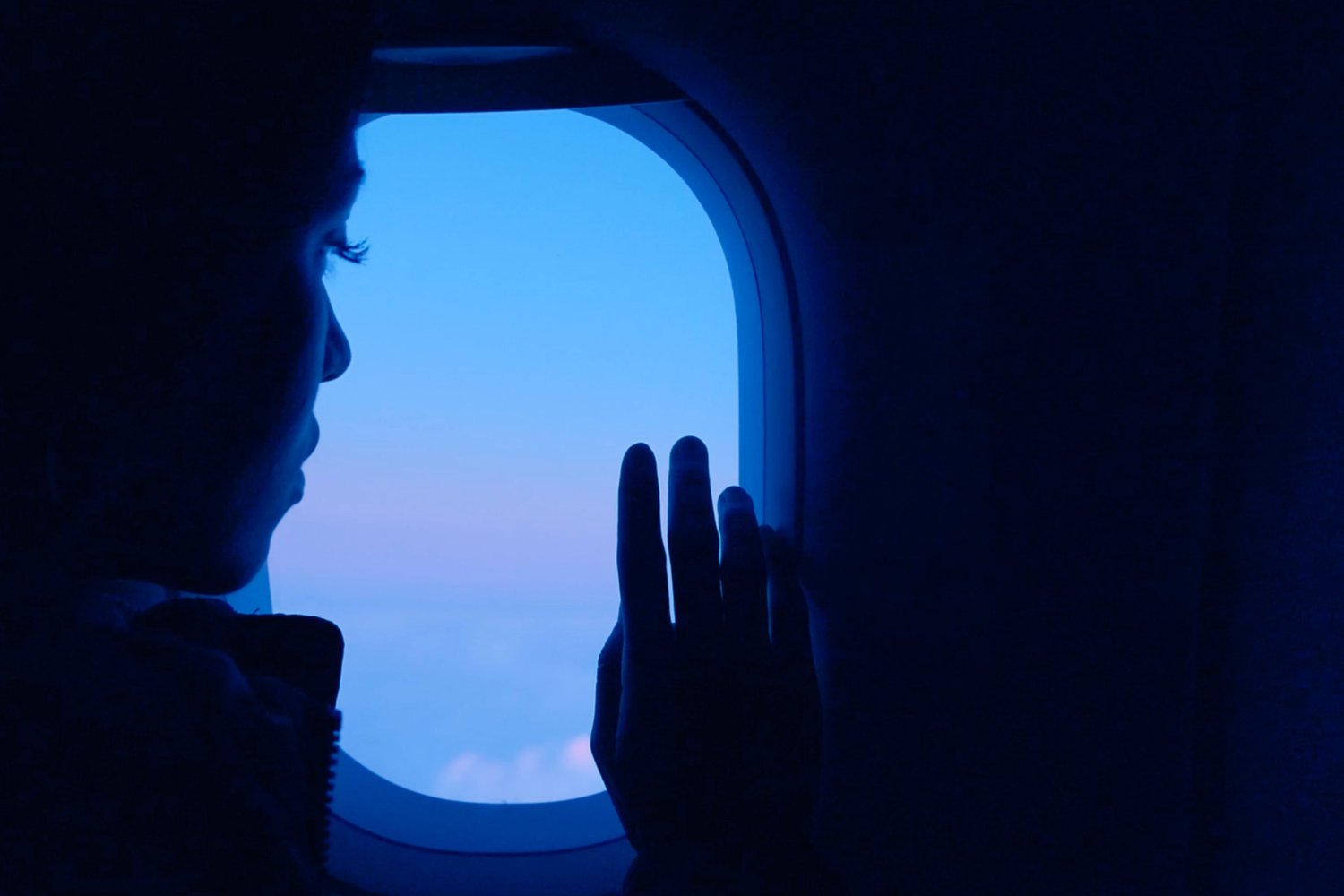 A person in an airplane, looking out the window