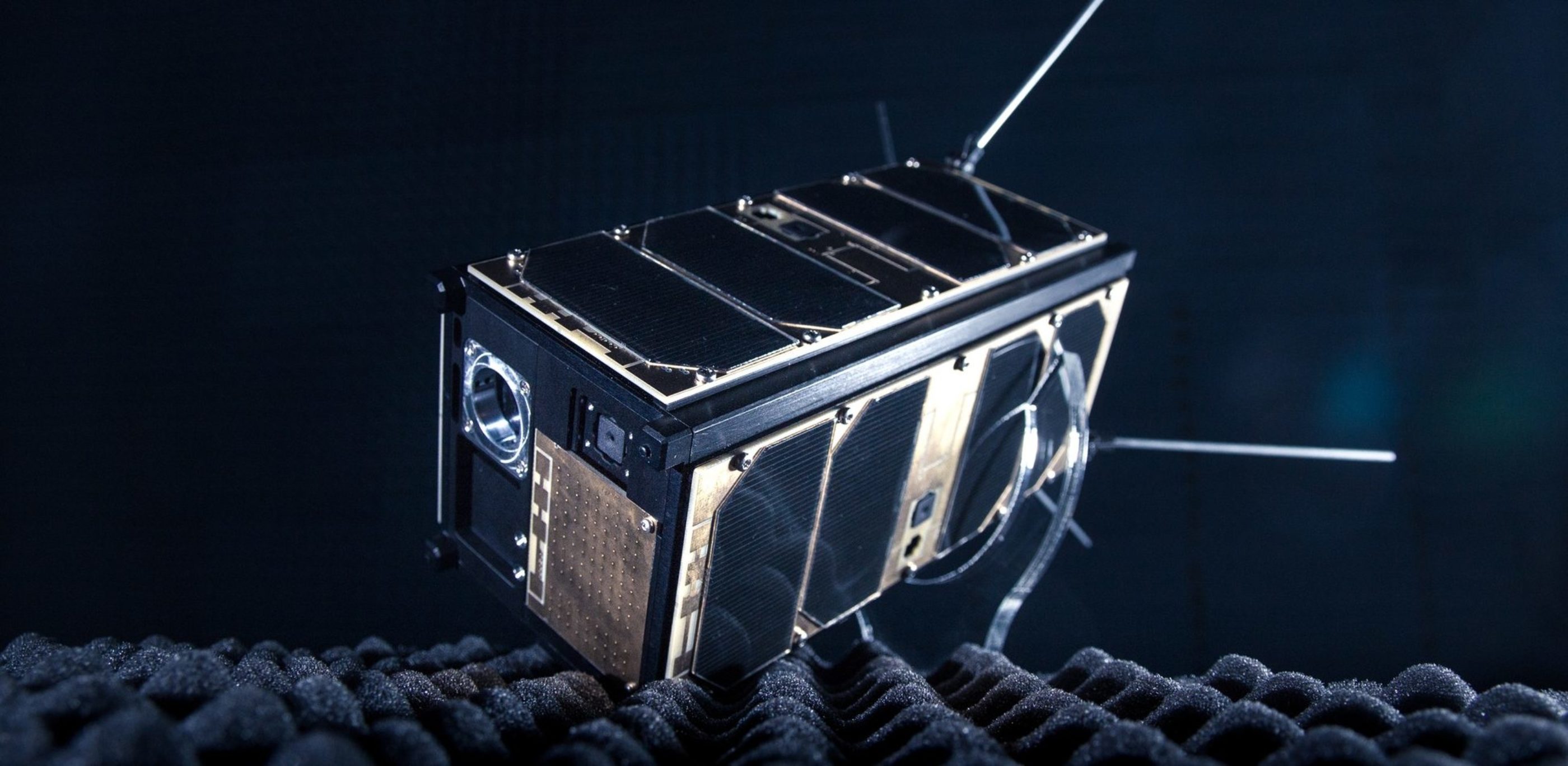 A black and gold satellite, with four antennae. 